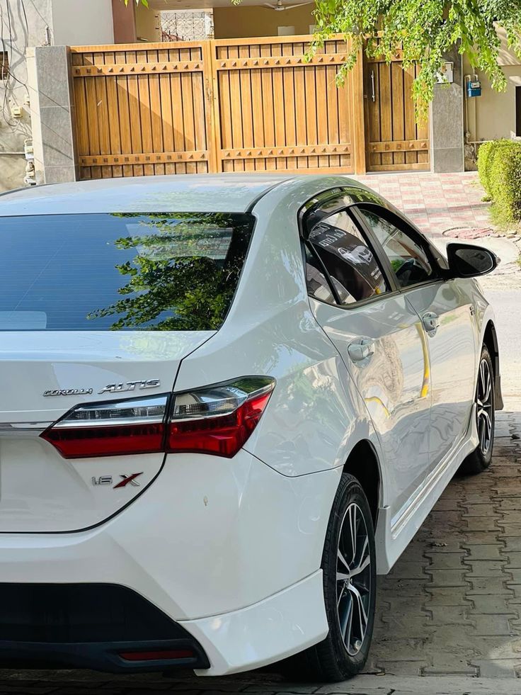 a white car parked in front of a house