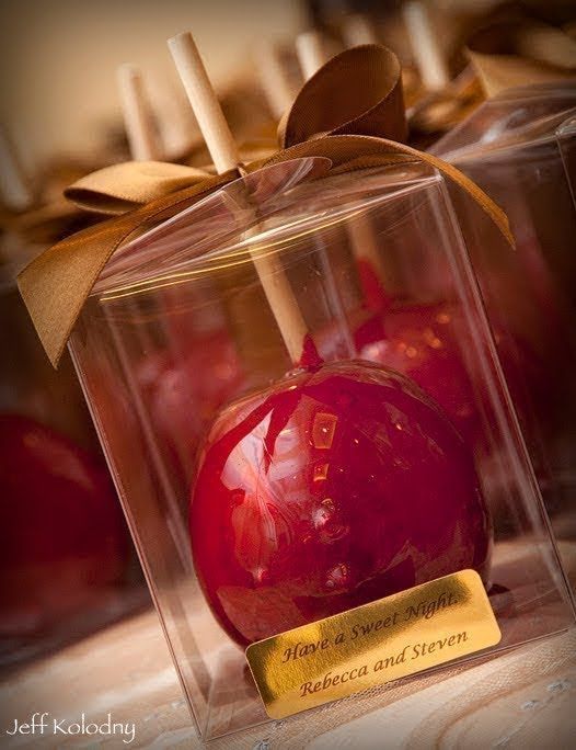 an apple in a glass box with a wooden stick sticking out of it's side