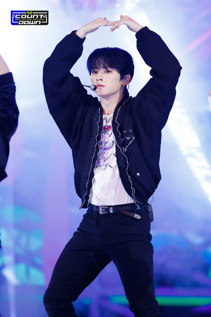 the young man is dancing on stage with his hands in the air