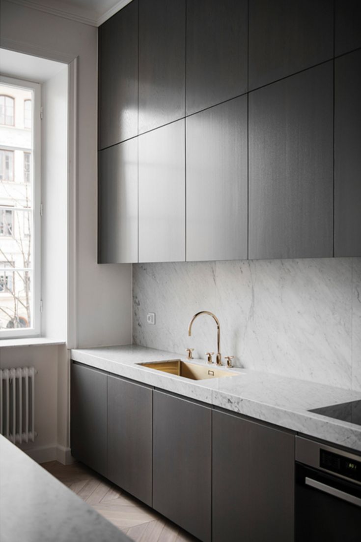 a kitchen with marble counter tops and stainless steel appliances in front of a large window