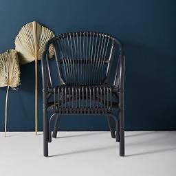 two wicker chairs next to each other in front of a blue wall