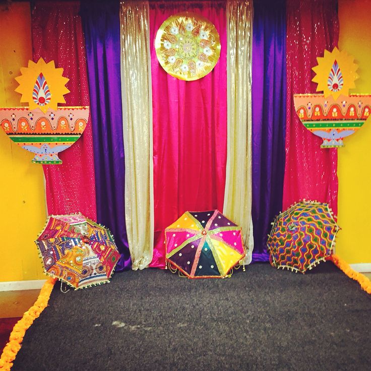 there are many colorful umbrellas in front of the stage set up for an event