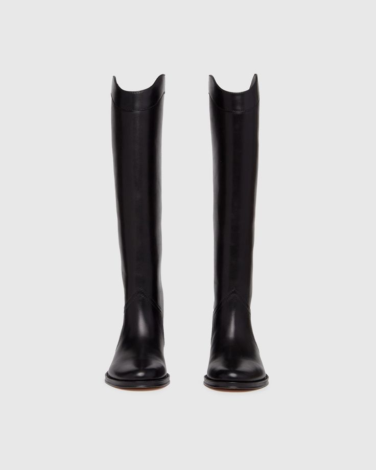 Raina is our take on the classic riding boot. Crafted from a super durable yet luxuriously soft black leather, this timeless straight shaft tall boot is designed with a curved topline that dips at the front and back for a flattering look, western-inspired pattern and stitch detailing, an extended leather welt with tonal stitch details, and a black leather stacked 20mm heel for a slight amount of lift. The classic menswear-inspired details on the outsole include stitching and half toplift for an Black Tall Boots Women, Riding Boot Outfit, Womens Tall Black Boots, Tall Boots Outfit, Riding Boot Outfits, Tall Western Boot, Capsule Wardrobe Women, Classic Menswear, Thigh Boots