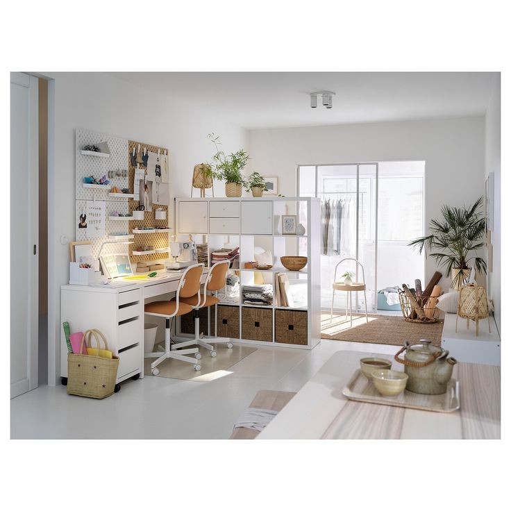 a white room with lots of furniture and plants on the shelves in front of it