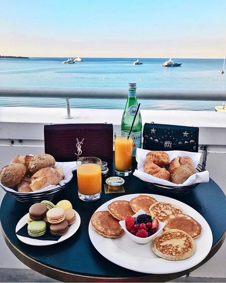 breakfast is served on the balcony overlooking the ocean and boats in the water, along with orange juice