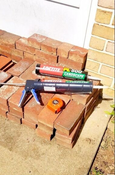 a brick wall with some tools on top of it next to bricks and a wrench