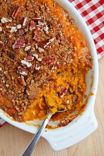 a casserole dish filled with sweet potato casserole and topped with pecans