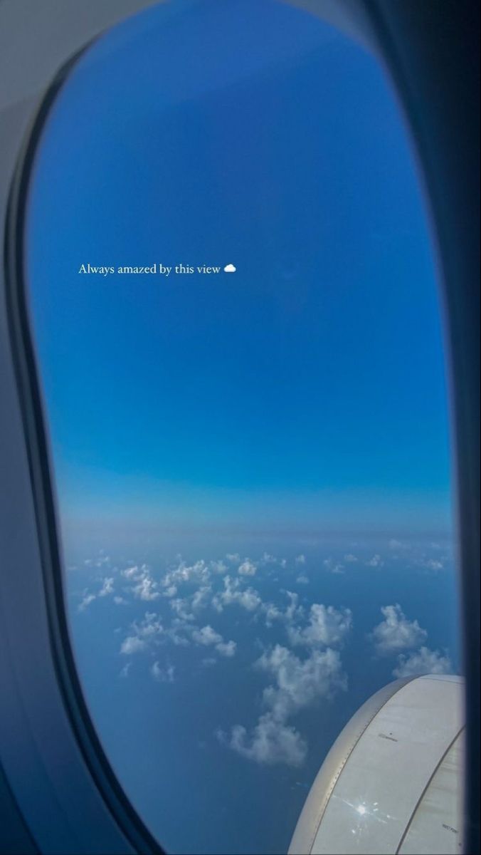 an airplane window looking out at the clouds