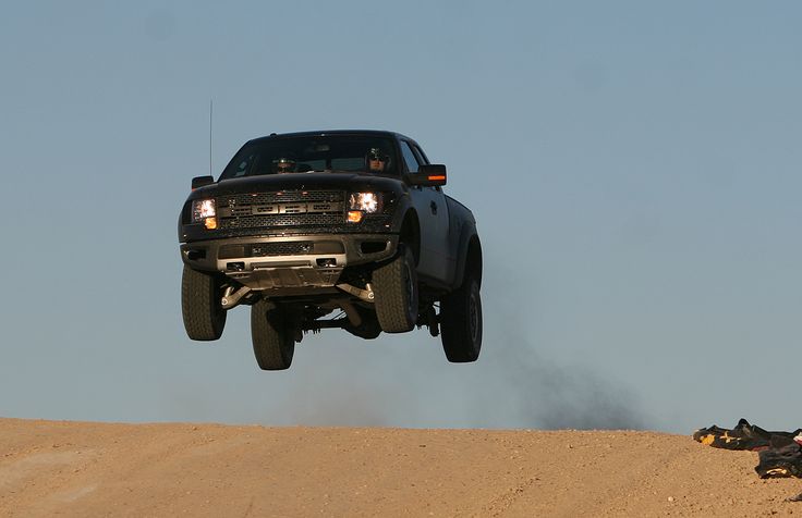 a black truck is flying through the air