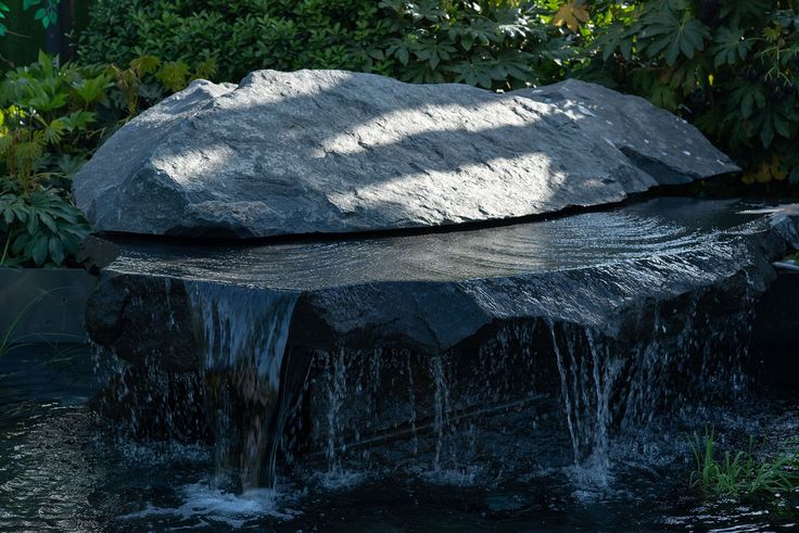 a large rock sitting on top of a body of water