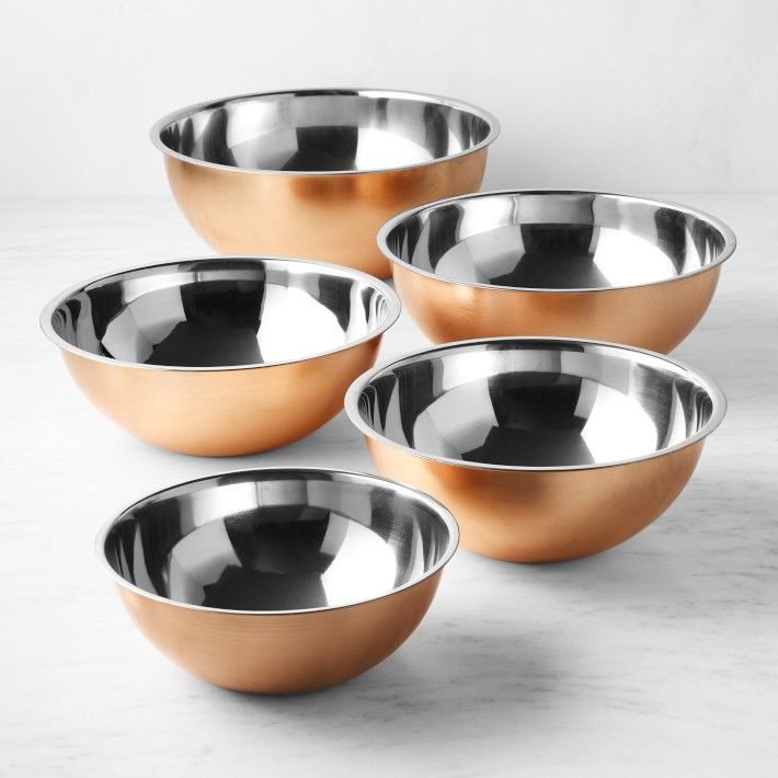 four metal bowls sitting on top of a table