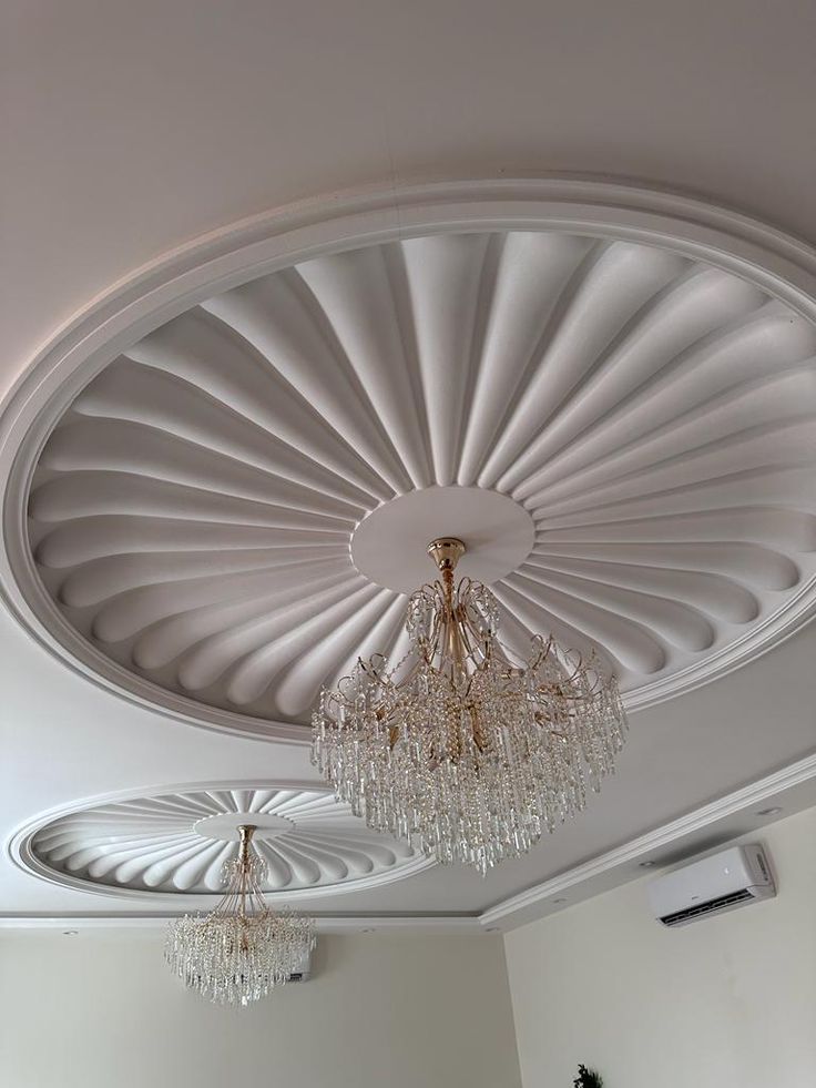 a living room filled with lots of furniture and a chandelier hanging from the ceiling