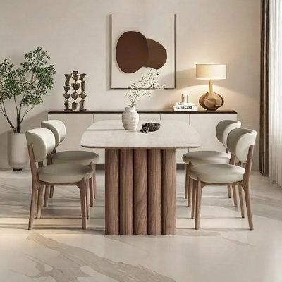 a dining room with white chairs and a marble table surrounded by vases on either side