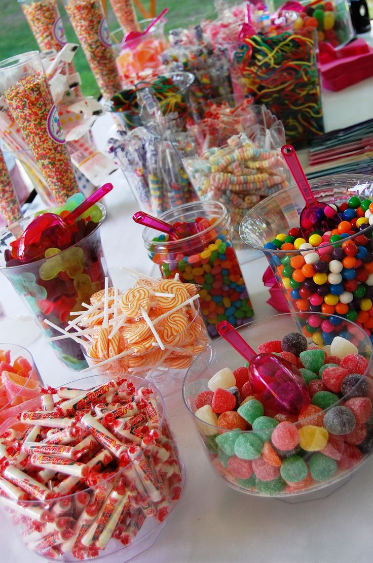 a table topped with lots of candy and lollipops on top of it