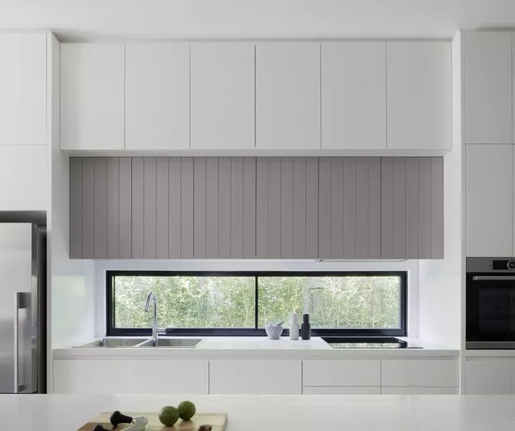 a modern kitchen with white cabinets and stainless steel appliances