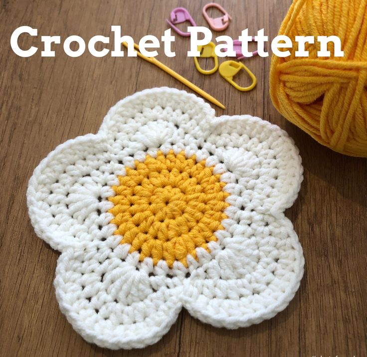 a crochet flower next to yarn and scissors on a table with the words crochet pattern written across it