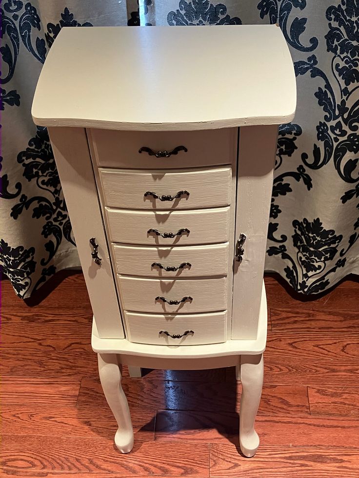 a white dresser with drawers on top of it