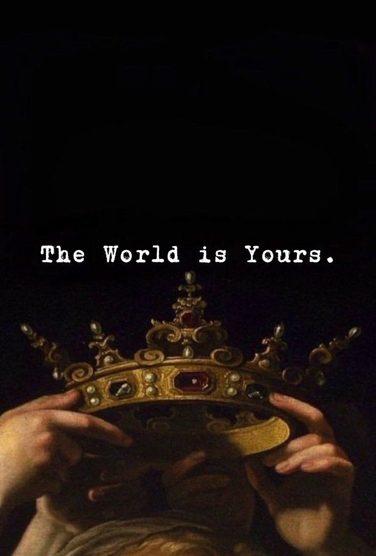 a man holding a crown over his face with the words, the world is yours