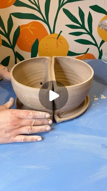 a person is making a bowl out of wood and clay with their hands on the table