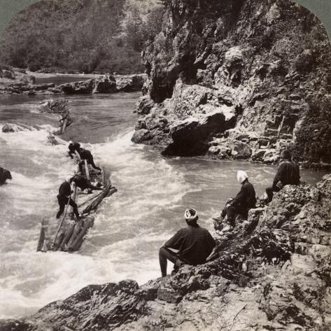 several people are sitting on rocks in the middle of a river, with rapids running between them