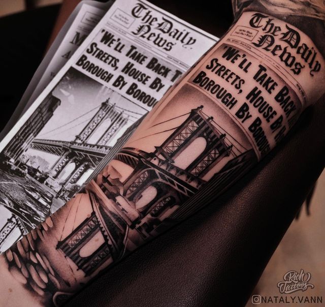 a man's arm with an old time newspaper and the brooklyn bridge tattoo on it