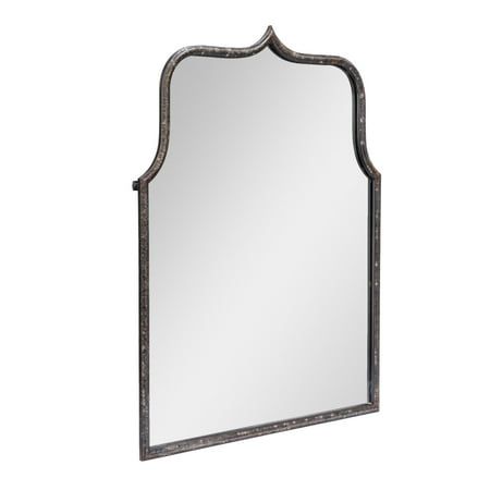 a mirror that is sitting on top of a white wall and has an ornate frame around it