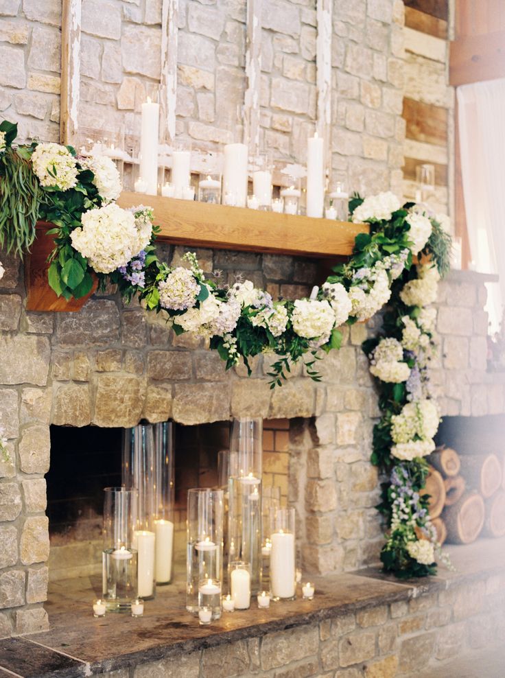 the fireplace is decorated with flowers and candles