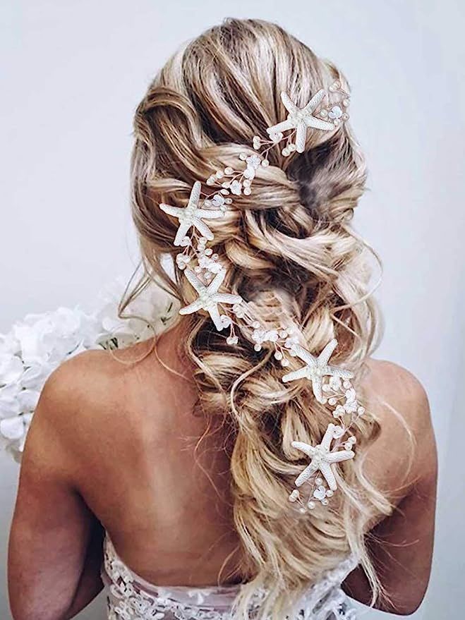 the back of a woman's head with long hair and flowers in her hair