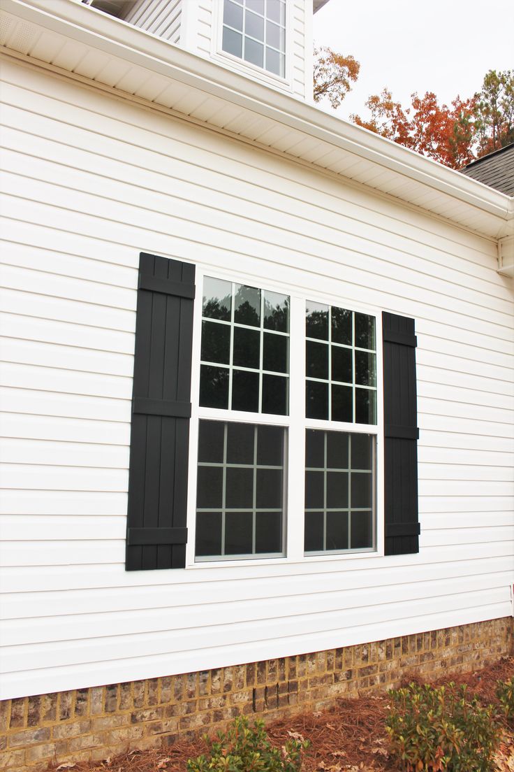 a white house with black shutters on the windows