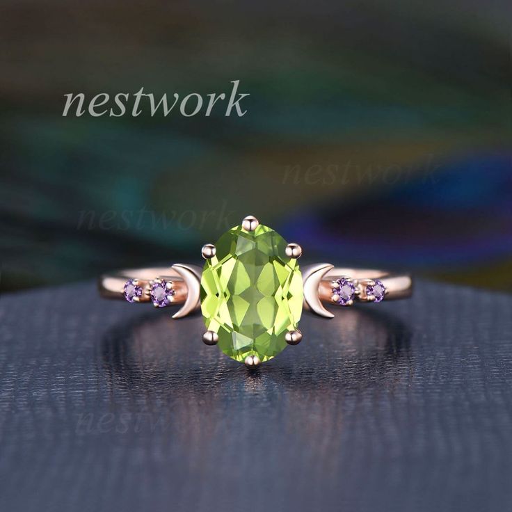 an oval cut peridot ring with three stones on the side and two diamonds in the middle