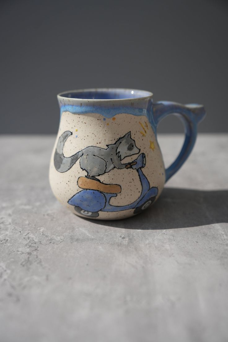 a blue and white mug with a cat on it