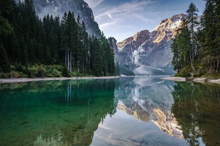 the mountains are reflected in the clear water