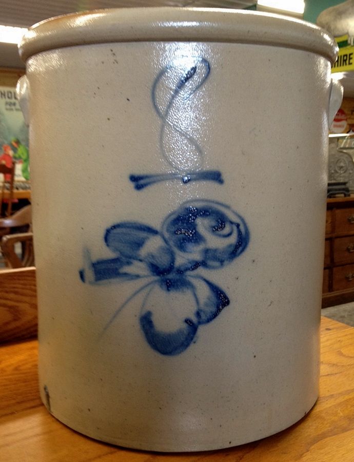 a blue and white pot sitting on top of a wooden table