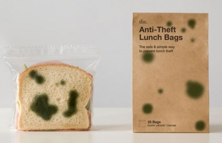 a sandwich in a plastic bag next to a brown package with green spots on it