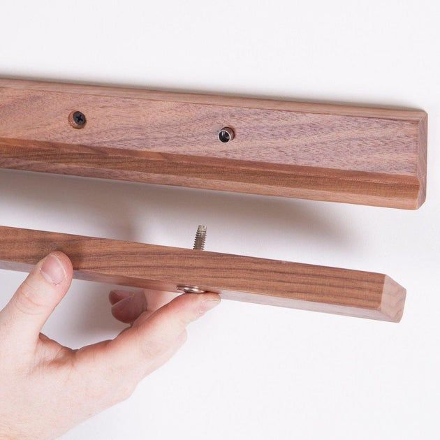 a person holding a wooden object with two holes in it