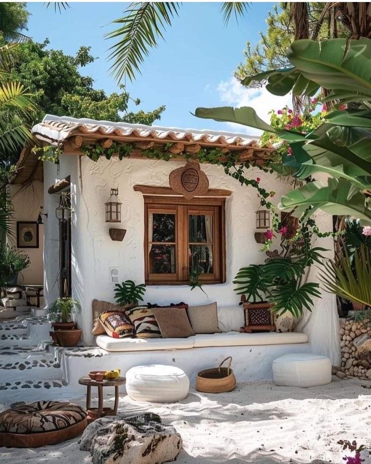 an outdoor living area with white furniture and tropical plants on the outside, along with potted palm trees