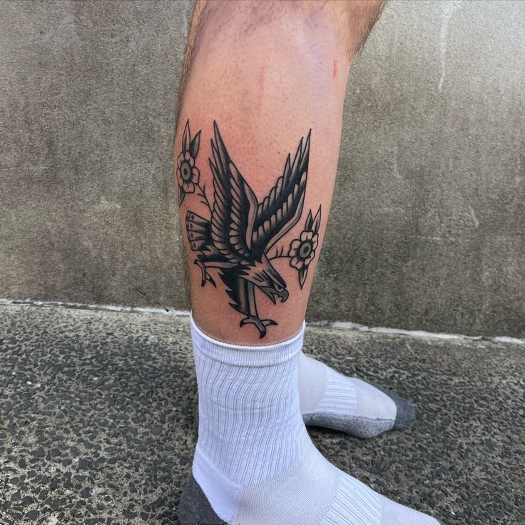 a man's leg with a bird tattoo on it