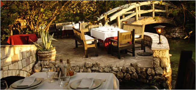 an outdoor dining area with tables and chairs set up for two people to eat at