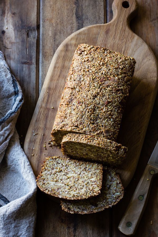 a loaf of bread sitting on top of a wooden cutting board next to a knife