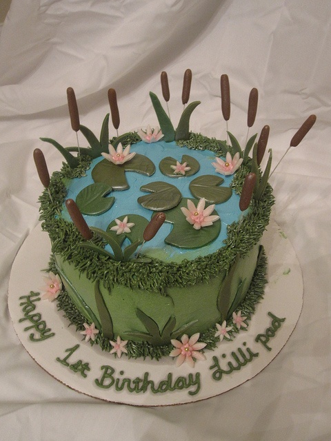 a birthday cake decorated with water lilies and grass