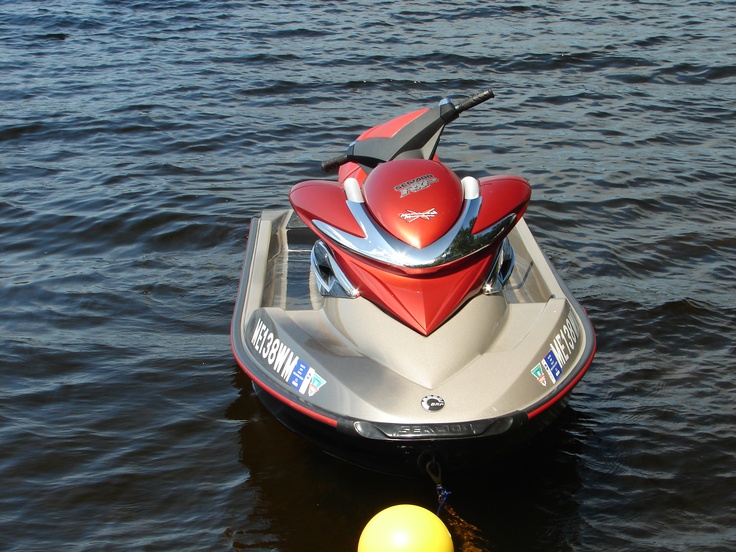 a red and silver jet ski is in the water next to a yellow buoy