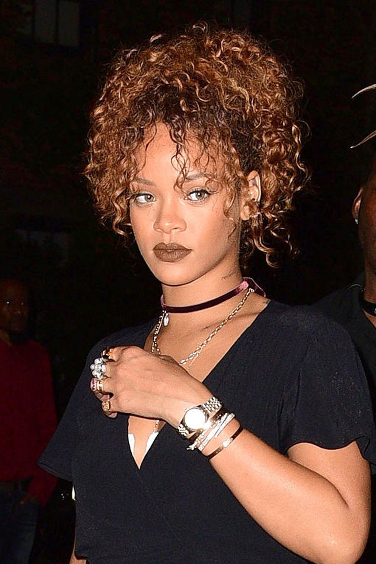 a close up of a person with a necklace and bracelet on her wrist, wearing a black top