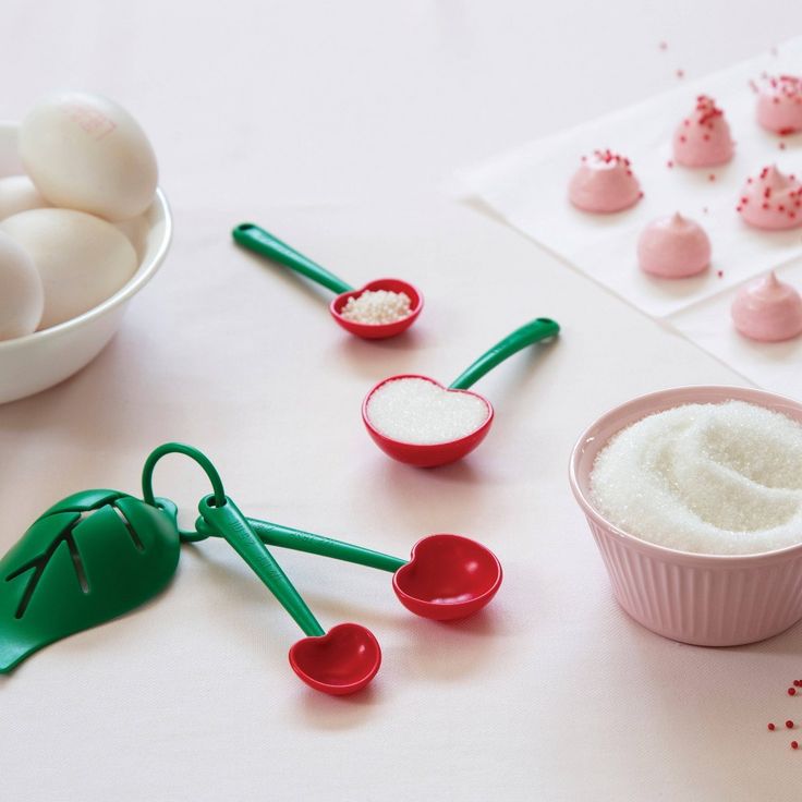 there are some spoons and bowls with food on the table