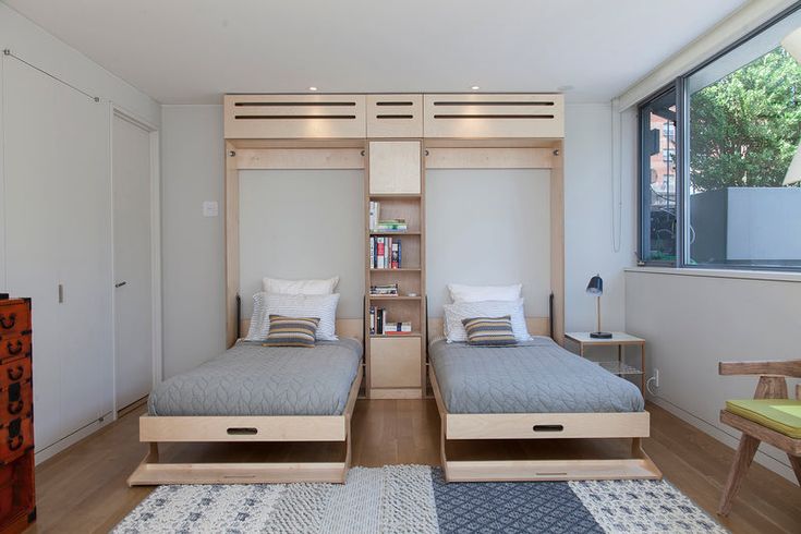 there are two beds in the room with built - in bookshelves on each side