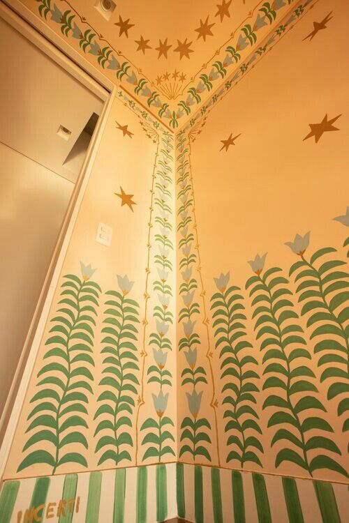 the ceiling is decorated with green and white stripes, stars, and swirls on it