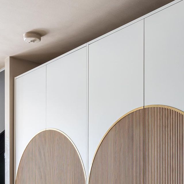 a room with white cupboards and wooden panels