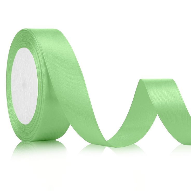 a roll of light green satin ribbon on a white background, with one side rolled up