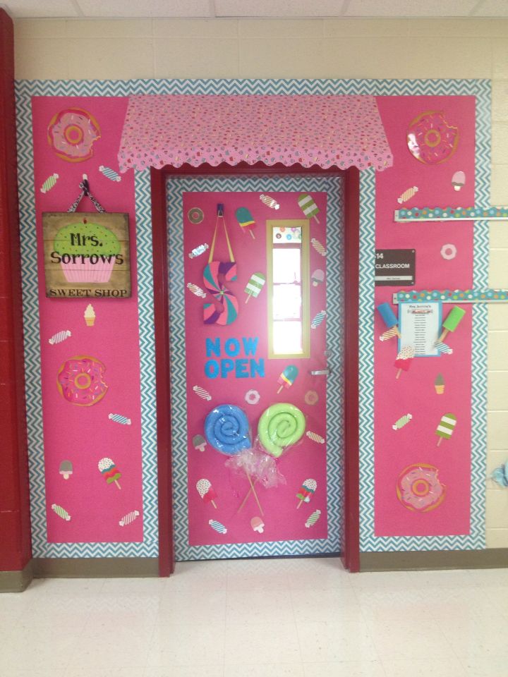 a pink door decorated with donuts, lollipops and candy