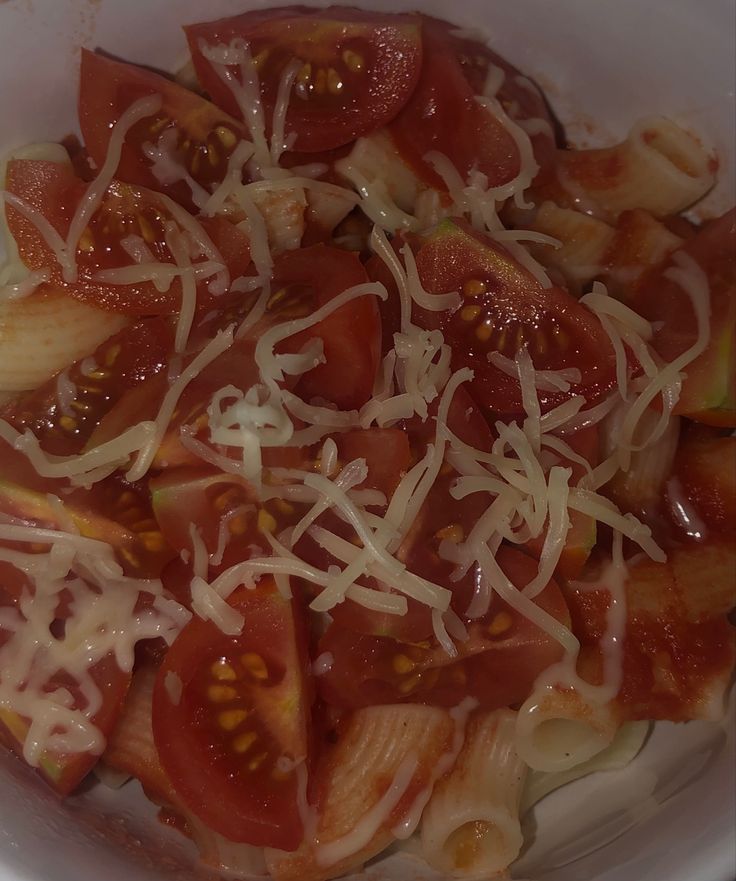 a white bowl filled with sliced tomatoes and cheese