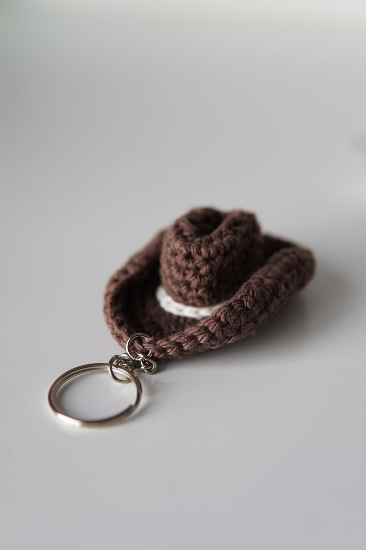 a crocheted keychain with a small hat on it's side